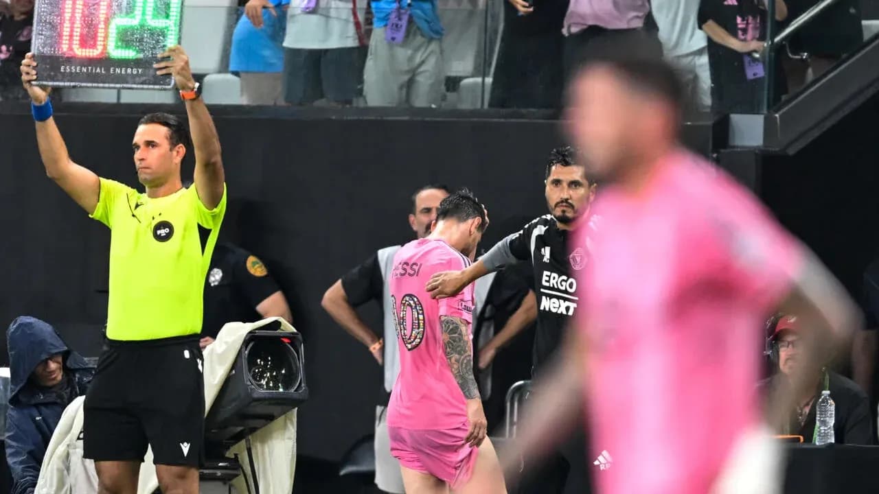 Jugador saliendo del campo con cartel de cambio