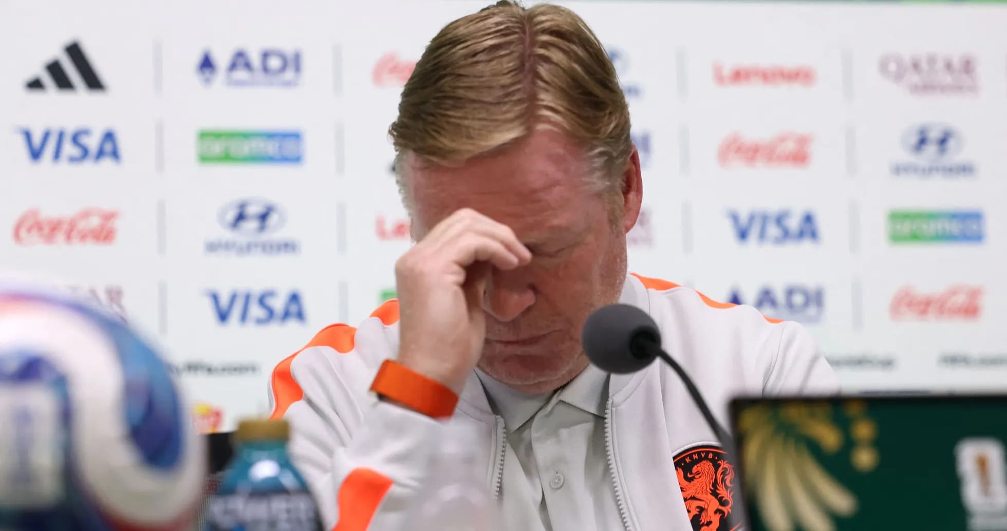 Entrenador en conferencia de prensa con la cabeza agachada