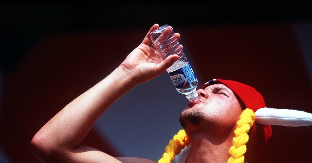 Hombre bebiendo agua de una botella en evento