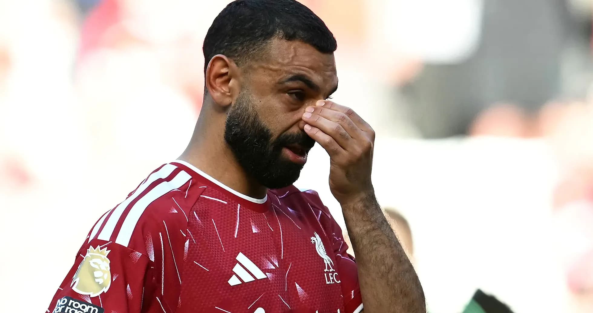 Jugador de Liverpool tocándose la cara en el campo