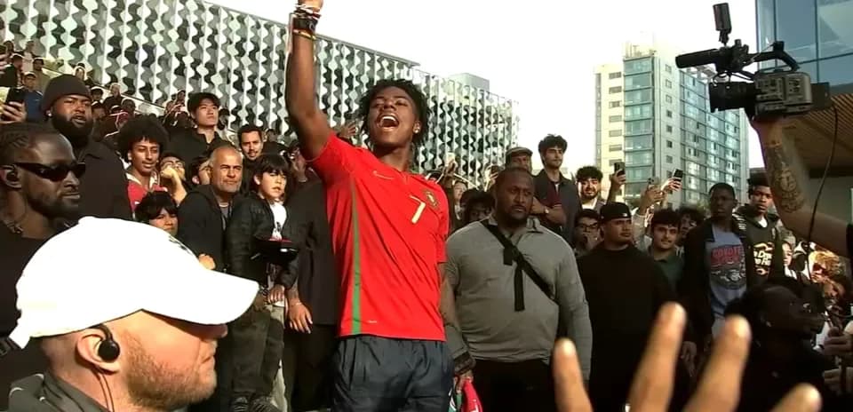 Joven con camiseta de Portugal levantando la mano en evento