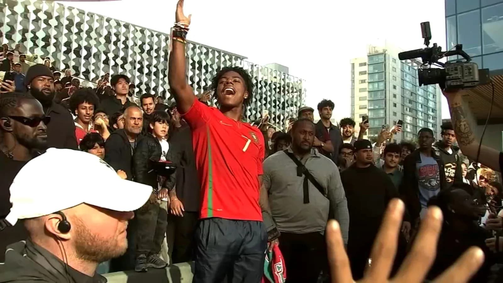 Joven con camiseta de Portugal levantando la mano en evento