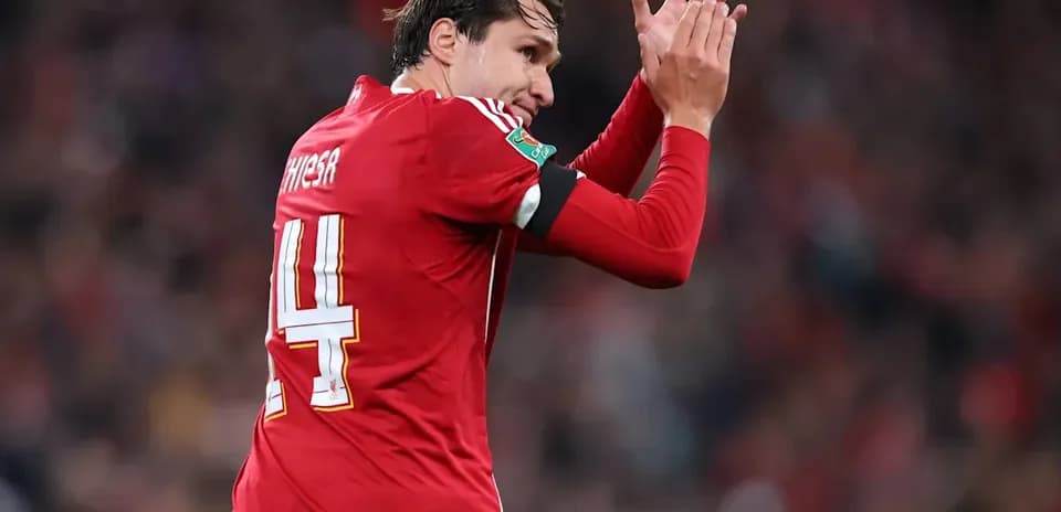 Jugador aplaudiendo con camiseta roja en el estadio