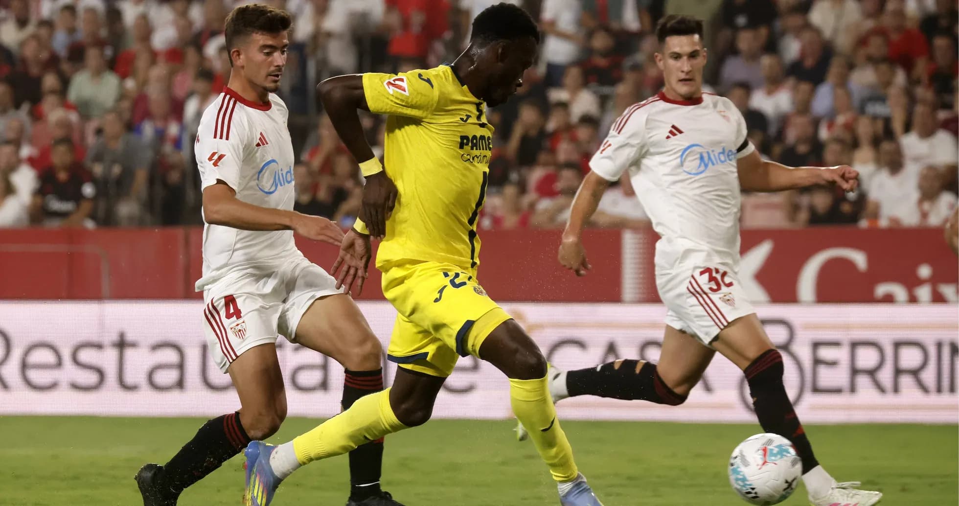 Jugadores de Villarreal y Sevilla compitiendo por el balón