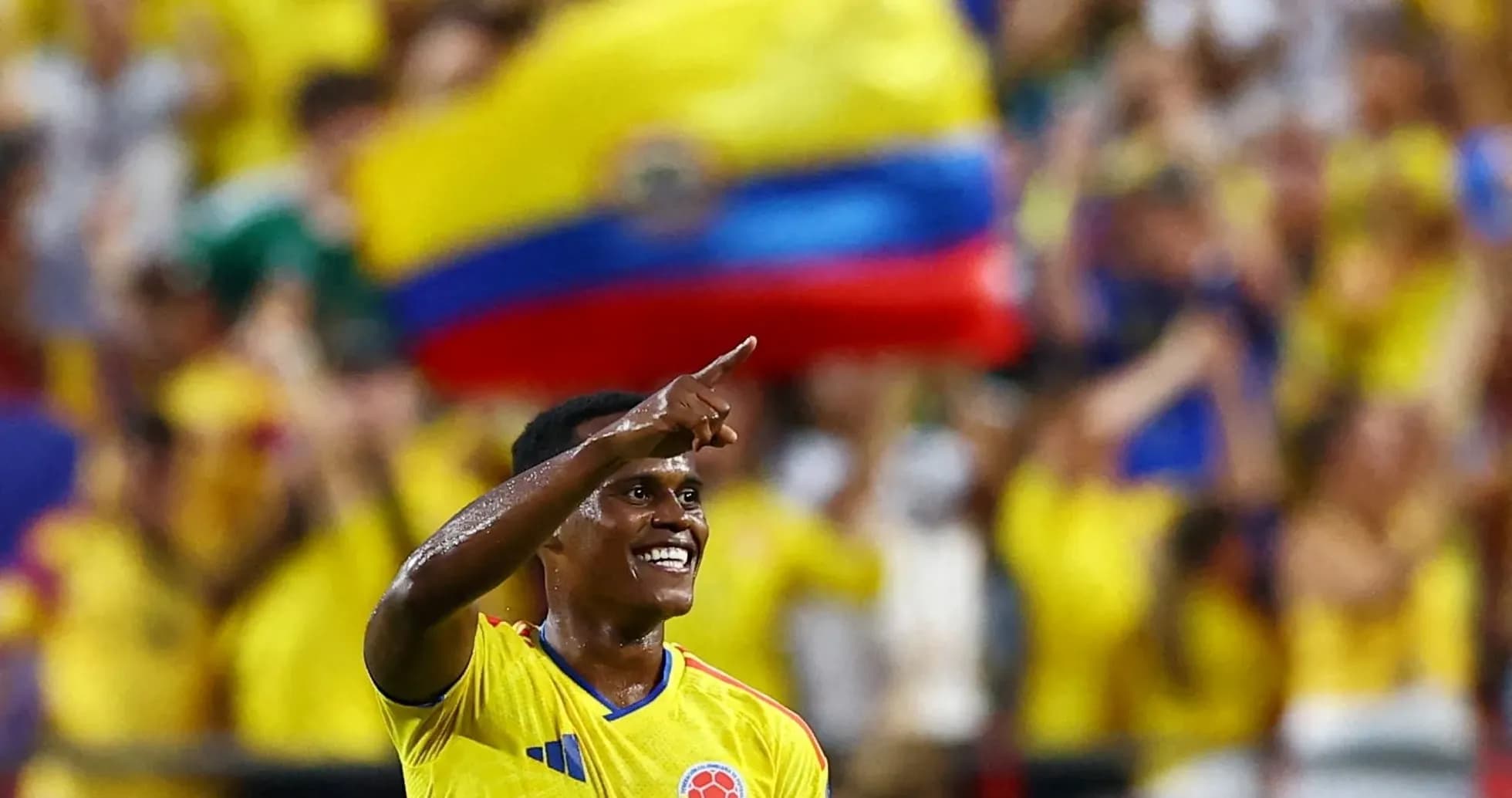 Jugador colombiano celebrando con aficionados en el fondo