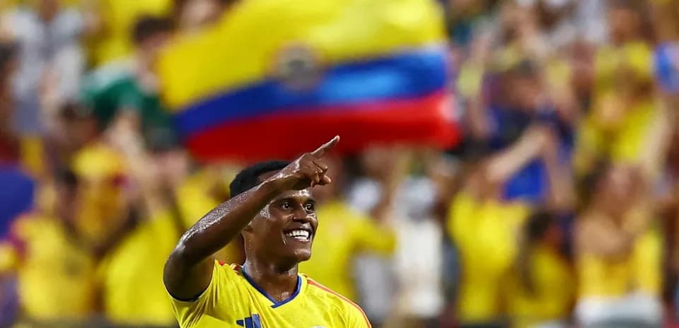 Jugador colombiano celebrando con aficionados en el fondo