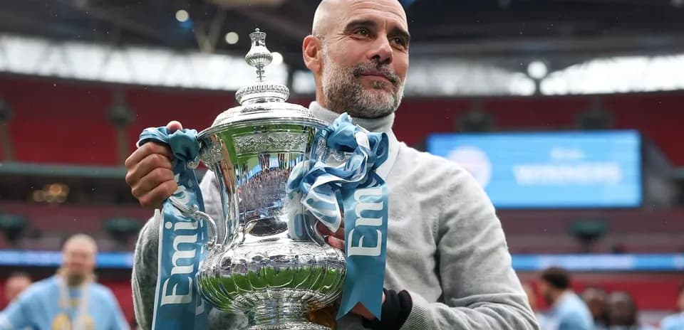 Entrenador sosteniendo el trofeo en el estadio