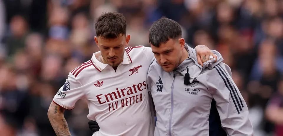 Jugador de Arsenal siendo ayudado por el personal médico