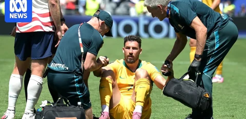 Jugador sentado siendo atendido por médicos en el campo