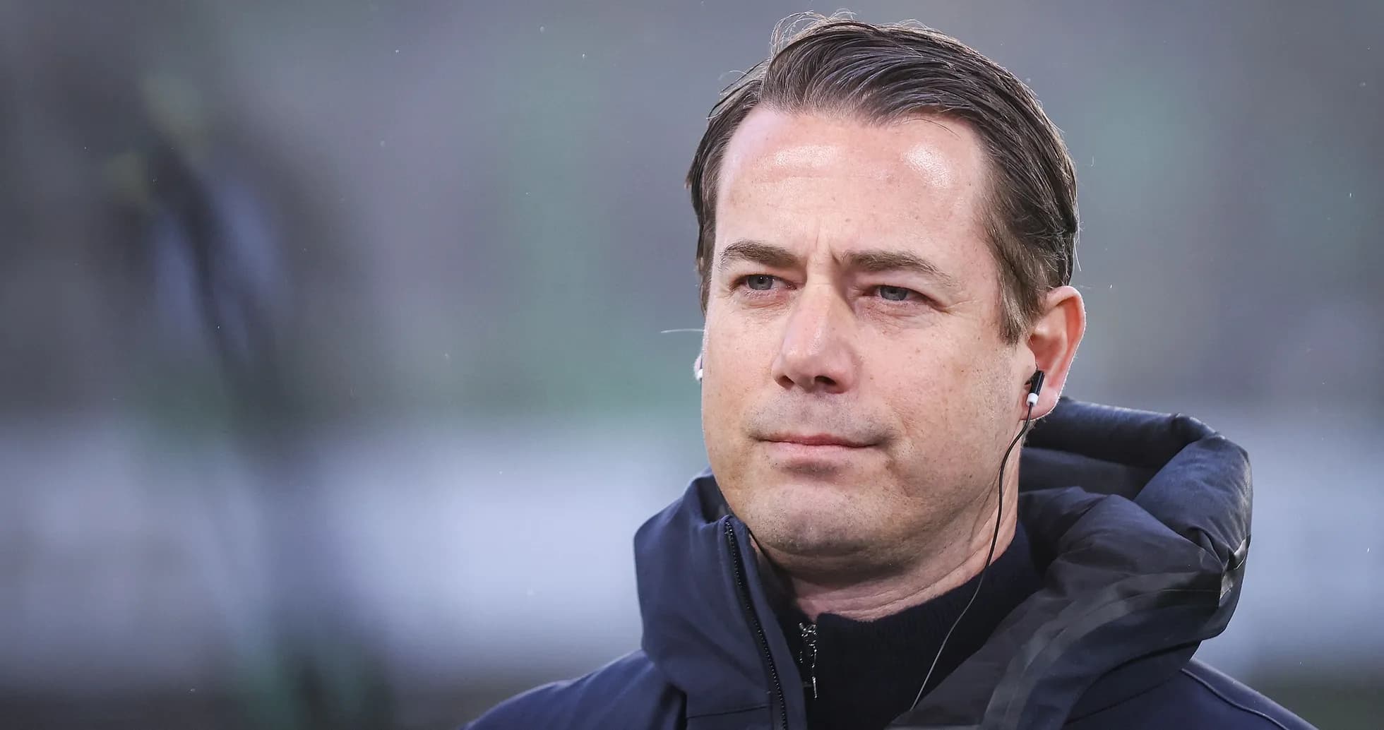 Entrenador con auriculares en el campo de juego