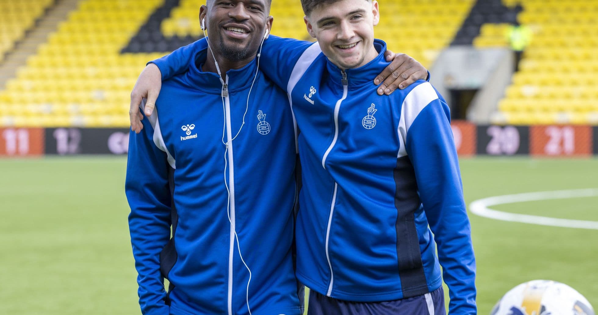Dos jugadores posando juntos en el campo de fútbol