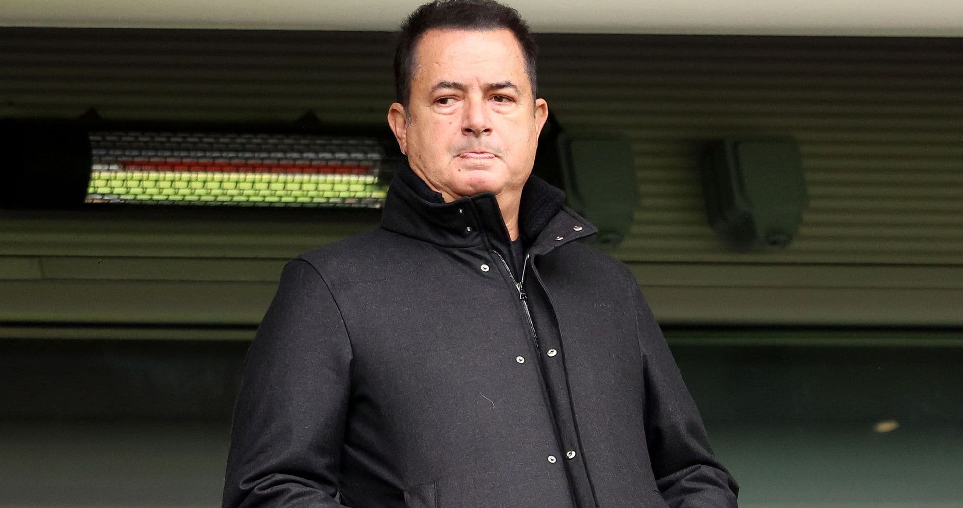 Hombre con abrigo oscuro en un estadio