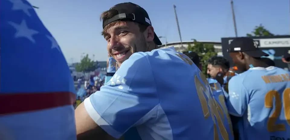Jugador sonriendo en evento con camiseta celeste