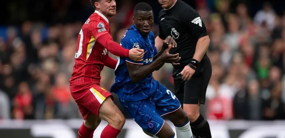 Jugador de Liverpool disputa el balón con jugador de Chelsea