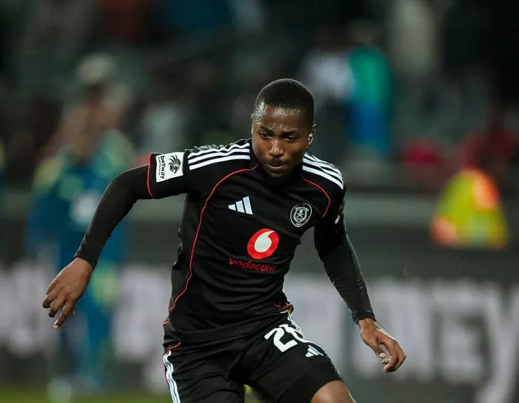 Jugador de Orlando Pirates corriendo con balón en campo Jugador de Orlando Pirates corriendo con balón en campo