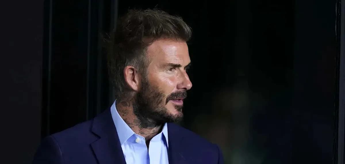 Hombre con barba y traje oscuro en perfil Hombre con barba y traje oscuro en perfil