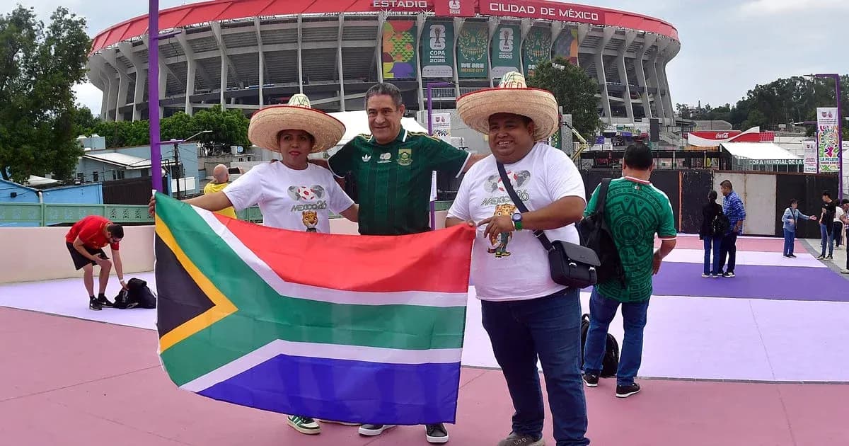 Aficionados sosteniendo bandera de Sudáfrica en estadio Aficionados sosteniendo bandera de Sudáfrica en estadio