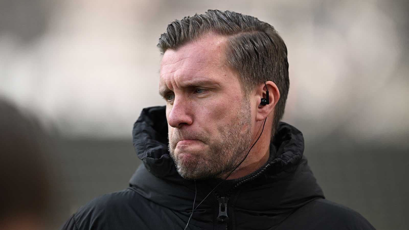 Entrenador con auriculares en un evento deportivo Entrenador con auriculares en un evento deportivo