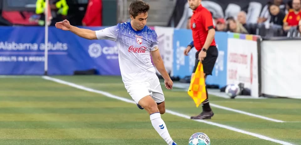 Jugador pateando el balón en un partido Jugador pateando el balón en un partido