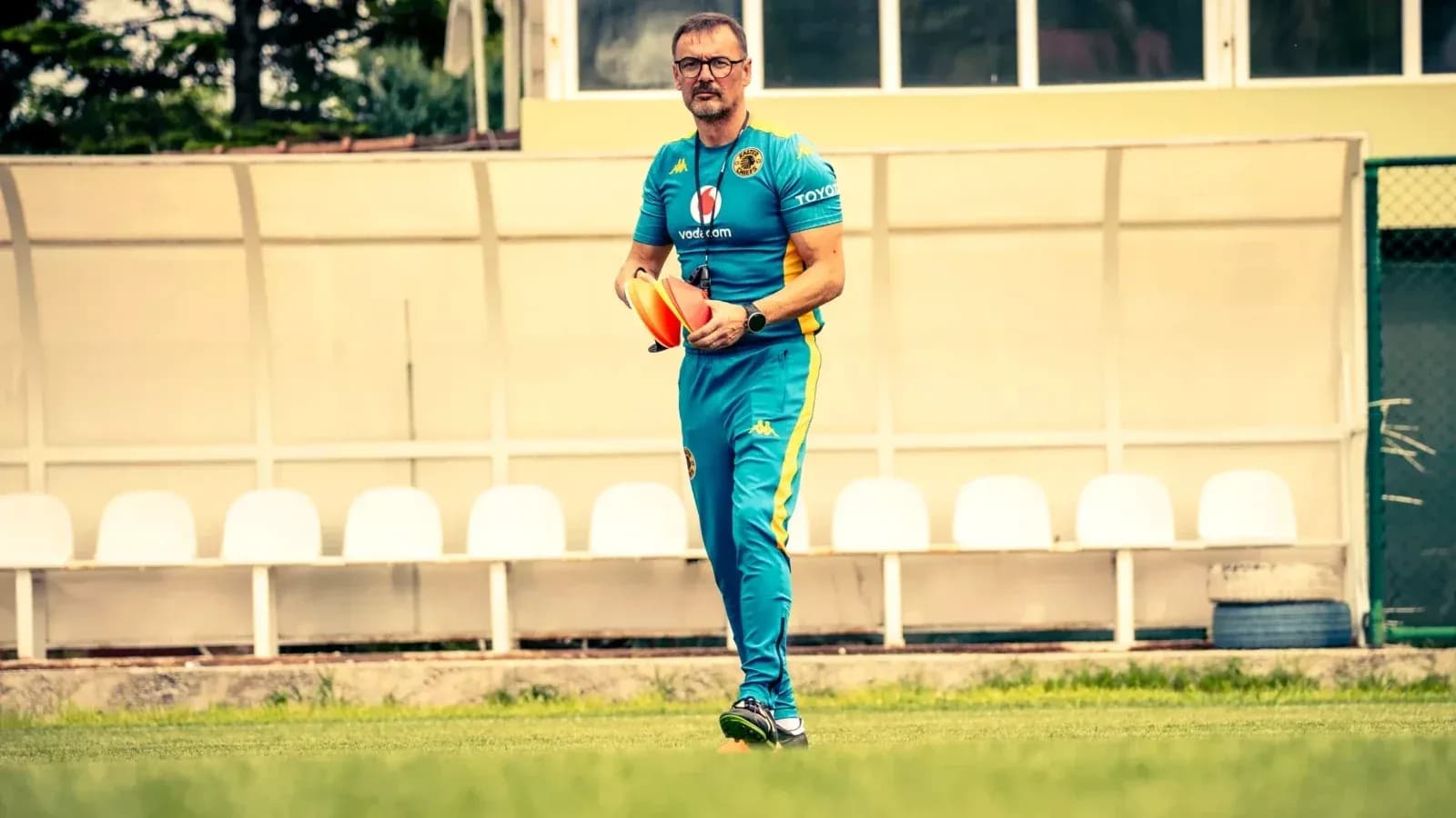 Entrenador con conos en el campo de entrenamiento Entrenador con conos en el campo de entrenamiento