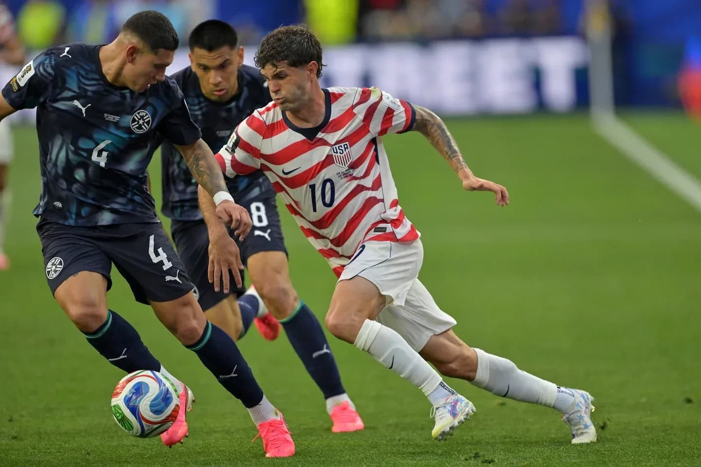 Christian Pulisic dribbling past Paraguayan defender Christian Pulisic dribbling past Paraguayan defender