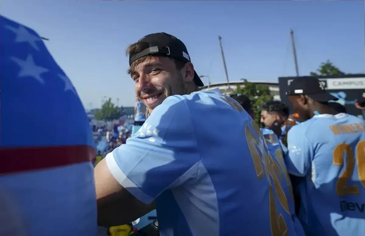 Jugador sonriendo en evento con camiseta celeste Jugador sonriendo en evento con camiseta celeste